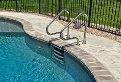 This in-wall ladder combines style and safety to the deep end of this pool